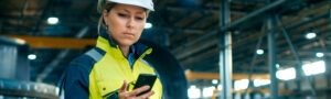 Connectivity is…imperative on the factory floor female worker on mobile phone on factory floor